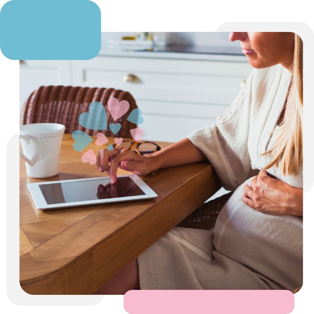 pregnant woman holding her belly whole using an ipad