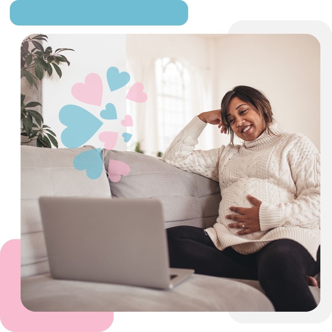 pregnant woman holding her belly whole using an laptop