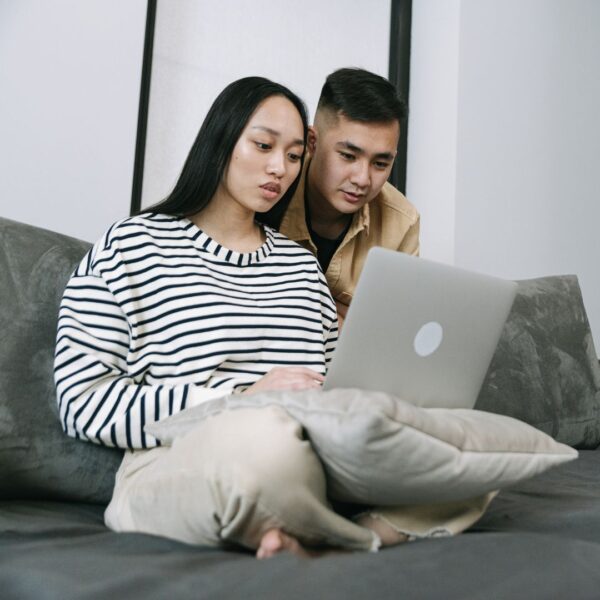 A young expecting family looking at trust adoption resources online.