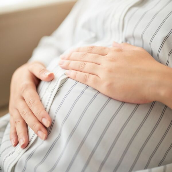 Pregnant woman holding her stomach.