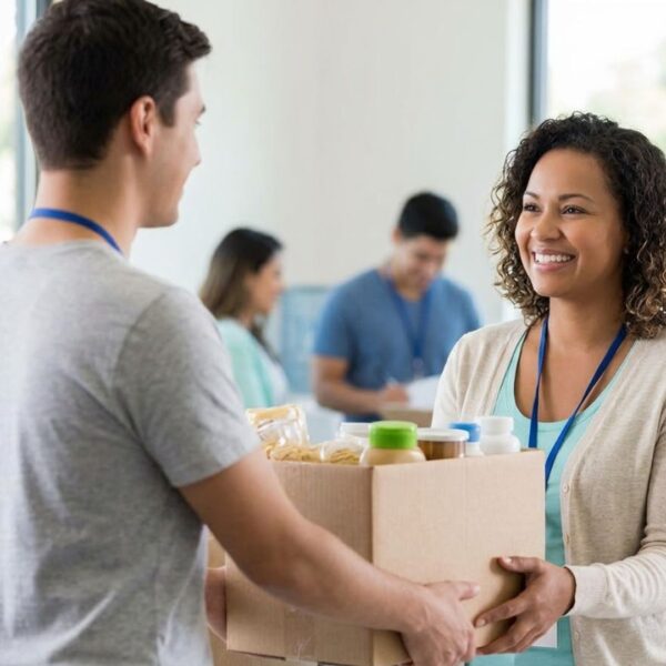 A volunteer handing a box of supplies to a woman